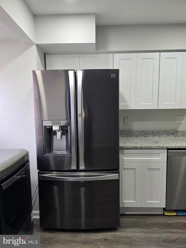 kitchen with appliances with stainless steel finishes, dark hardwood / wood-style floors, white cabinets, and light stone counters