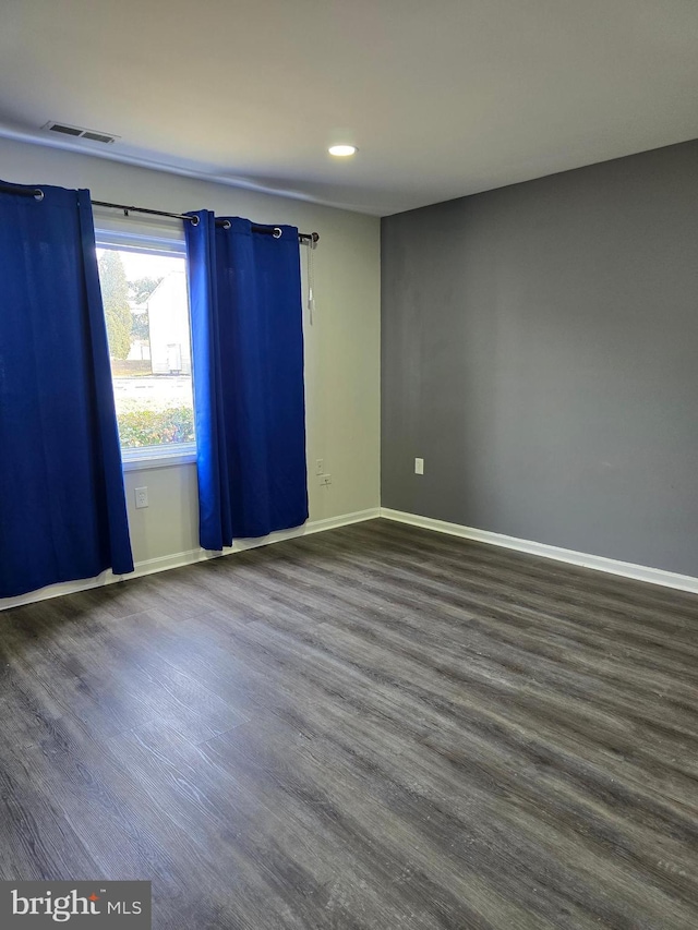 unfurnished room with dark hardwood / wood-style flooring