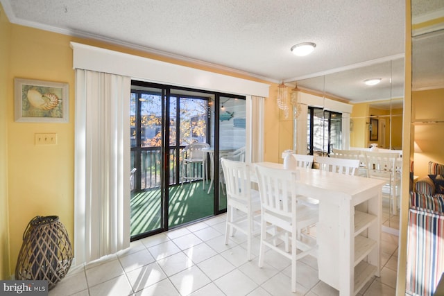 dining area featuring ornamental molding, light tile patterned flooring, and a textured ceiling