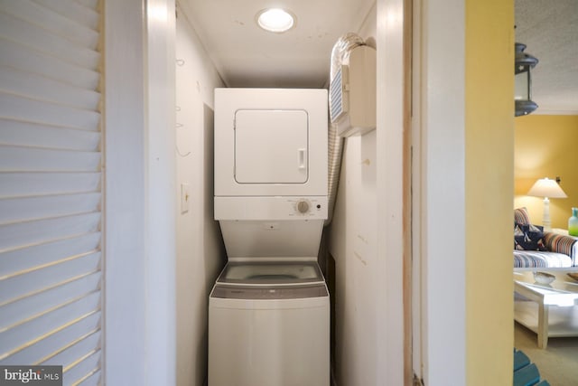 washroom featuring stacked washer / drying machine