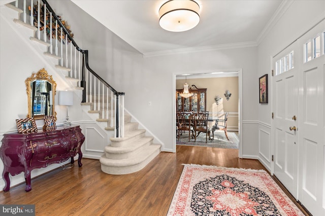 foyer with crown molding and dark hardwood / wood-style floors