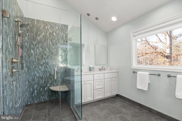 bathroom with vaulted ceiling, vanity, and a shower with shower door