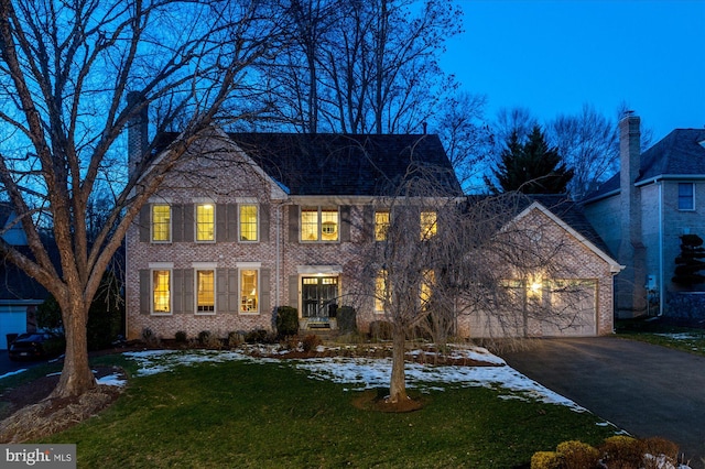 colonial-style house with a garage and a lawn