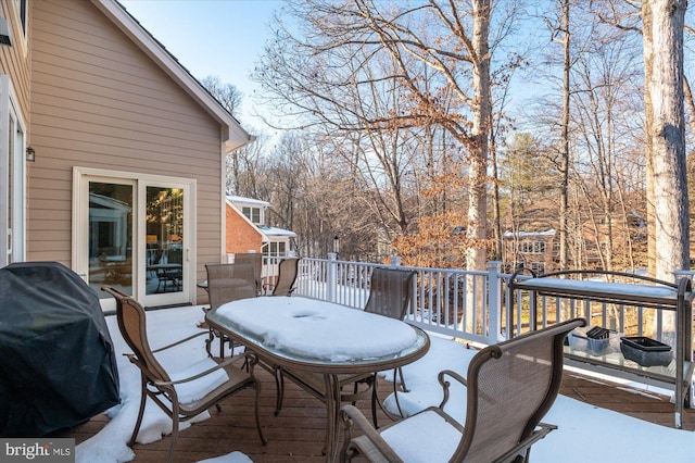 snow covered deck with a grill