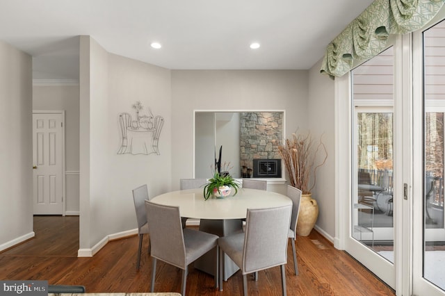 dining space featuring dark hardwood / wood-style flooring and a stone fireplace