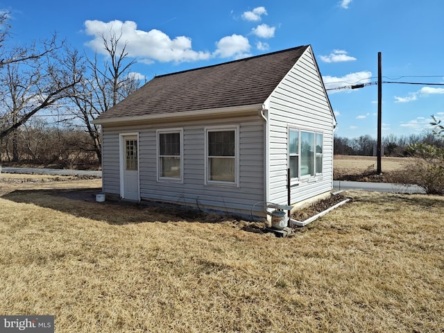 view of property exterior featuring roof with shingles and a lawn