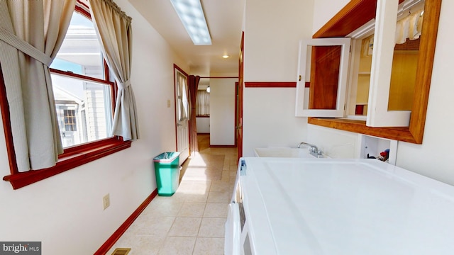 full bathroom with a sink, tile patterned flooring, and baseboards