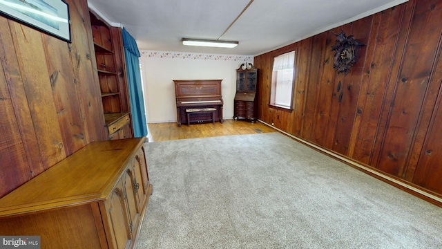 unfurnished living room with light carpet and wooden walls