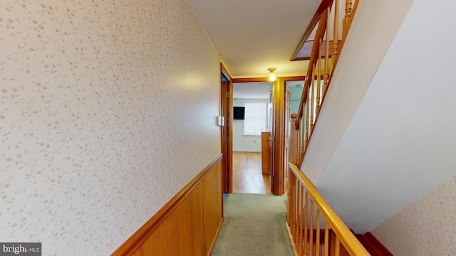 corridor with carpet floors, a wainscoted wall, stairway, and wallpapered walls