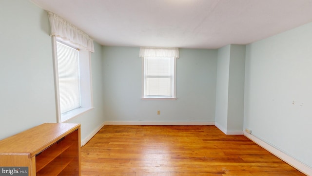 spare room featuring light wood-style floors and baseboards