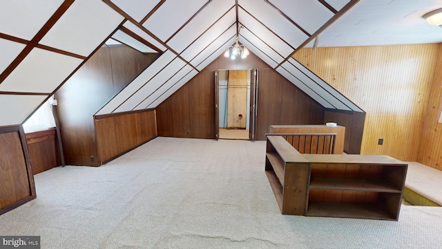 additional living space featuring wooden walls, vaulted ceiling, and light carpet