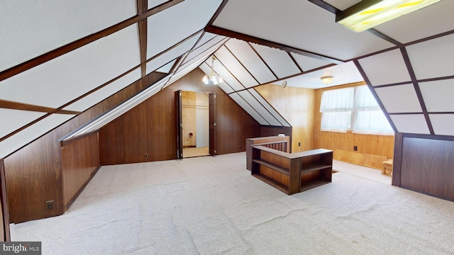 additional living space with light colored carpet, vaulted ceiling, and wooden walls