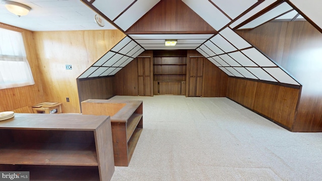 additional living space featuring light colored carpet, lofted ceiling, and wooden walls