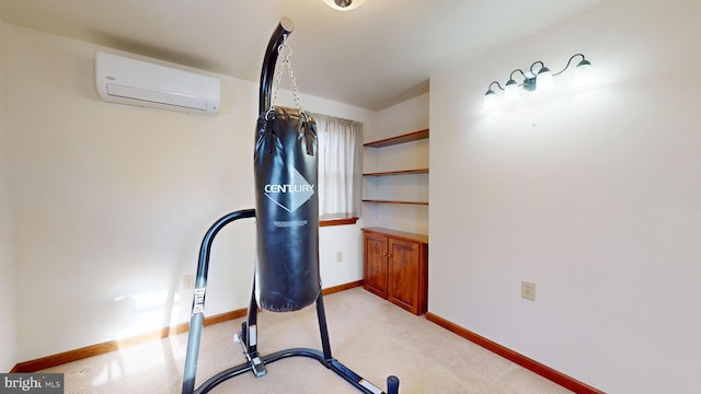 workout room featuring a wall unit AC, baseboards, and light colored carpet