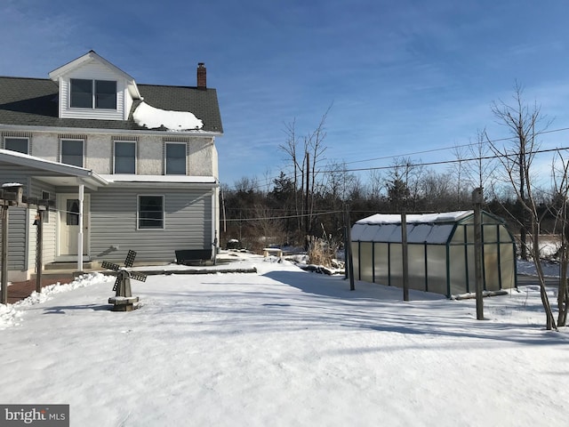 view of snowy exterior featuring an outbuilding