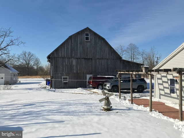 snow covered structure with an outdoor structure and a barn