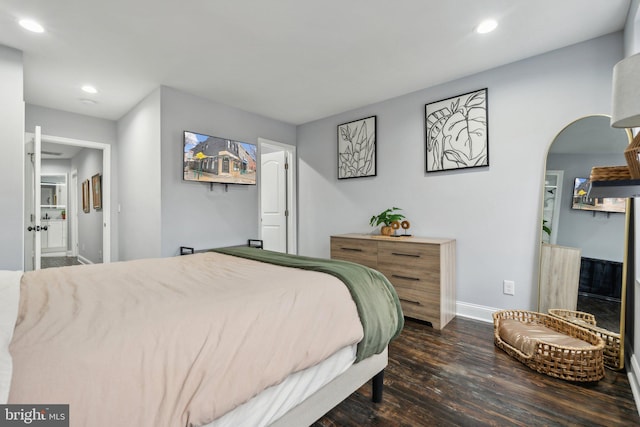 bedroom featuring connected bathroom and dark hardwood / wood-style floors