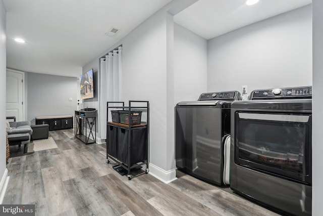 laundry area featuring washer and dryer and wood-type flooring