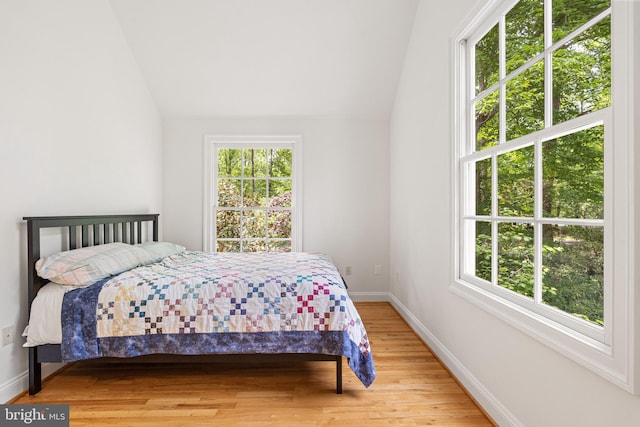 bedroom featuring lofted ceiling and light hardwood / wood-style floors