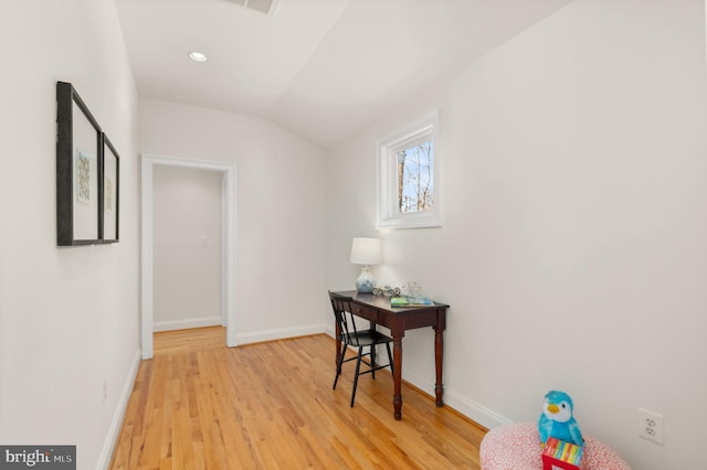 hallway with lofted ceiling and light hardwood / wood-style flooring