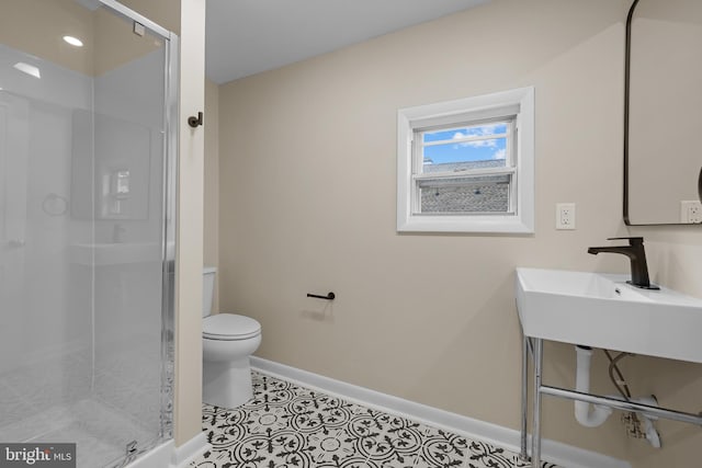 bathroom featuring a shower with shower door, sink, toilet, and tile patterned flooring