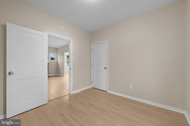 empty room with light hardwood / wood-style flooring