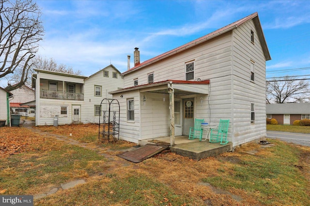 rear view of house featuring a yard and a patio