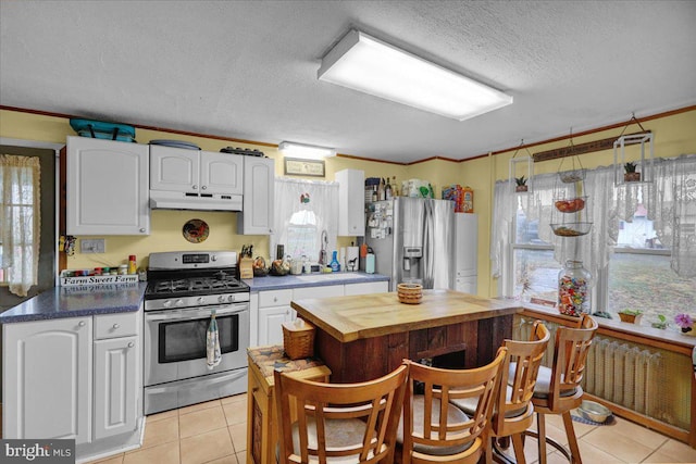 kitchen with a wealth of natural light, white cabinets, and appliances with stainless steel finishes