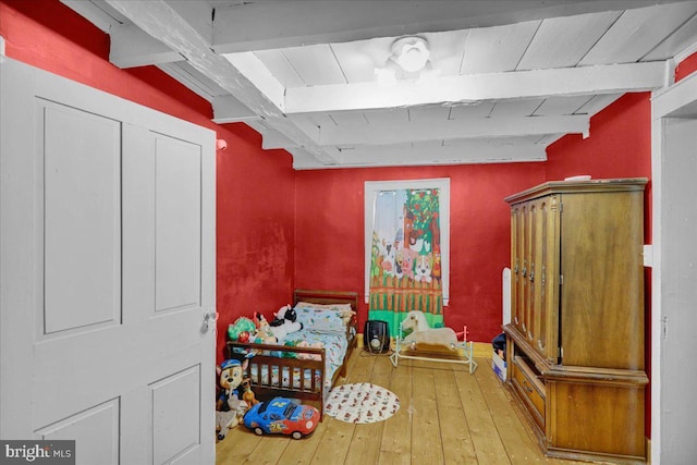 interior space with beam ceiling and hardwood / wood-style flooring