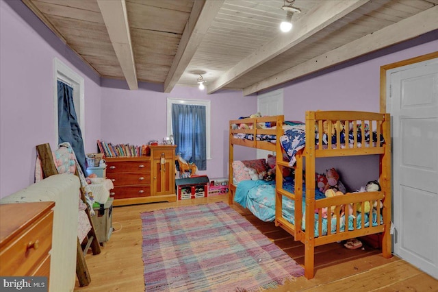 bedroom with beamed ceiling and light hardwood / wood-style flooring