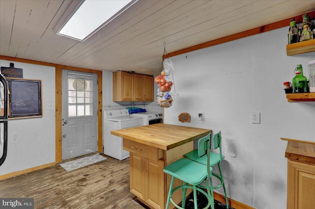 kitchen featuring washer and clothes dryer, butcher block countertops, wood-type flooring, and wooden ceiling