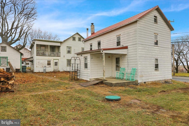 rear view of house featuring a lawn