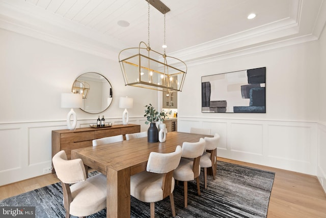 dining area with hardwood / wood-style floors, wooden ceiling, a raised ceiling, crown molding, and a chandelier