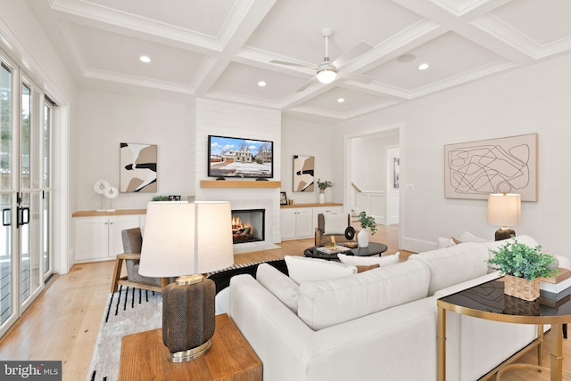 living room featuring beam ceiling, ceiling fan, coffered ceiling, light wood-type flooring, and ornamental molding