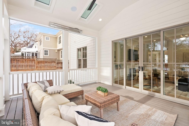 sunroom / solarium featuring vaulted ceiling with skylight