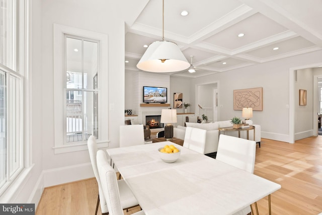 dining area with light hardwood / wood-style floors, beam ceiling, and coffered ceiling