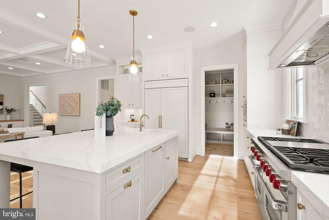 kitchen with white cabinetry, an island with sink, custom range hood, and high end appliances