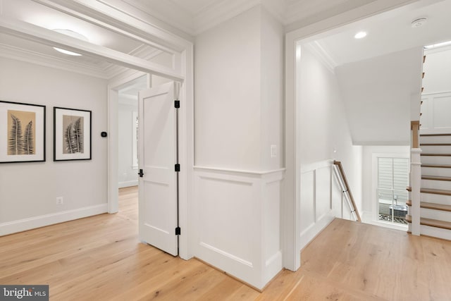 hallway featuring light wood-type flooring and ornamental molding