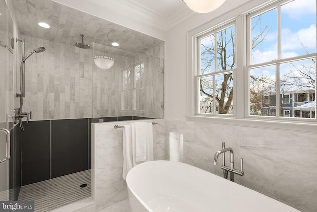 bathroom with shower with separate bathtub, ornamental molding, and tile walls