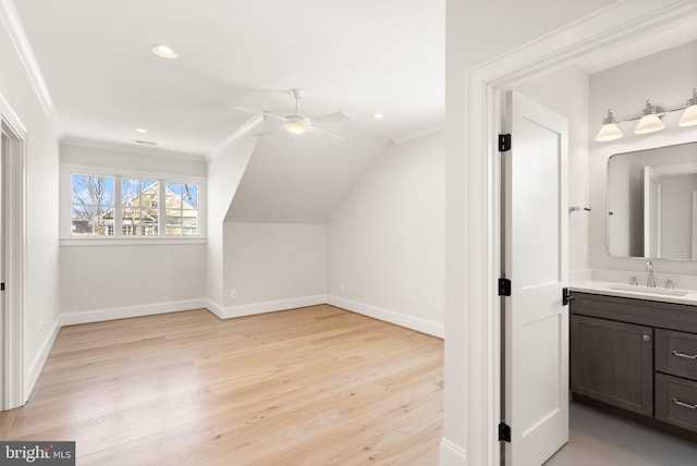 additional living space featuring light hardwood / wood-style floors, vaulted ceiling, ceiling fan, and sink