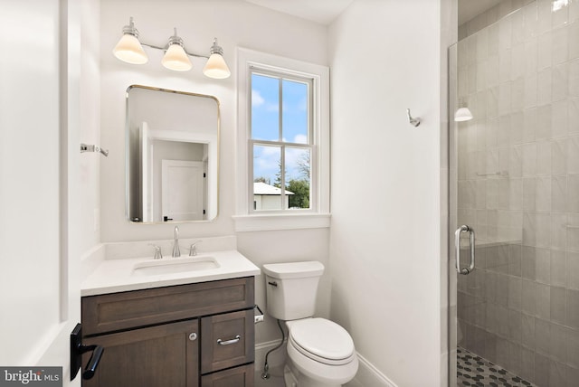 bathroom with vanity, toilet, and a shower with door