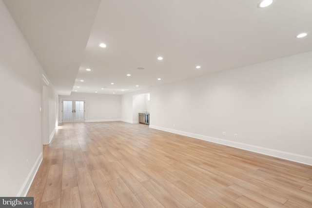 unfurnished living room featuring french doors and light hardwood / wood-style floors