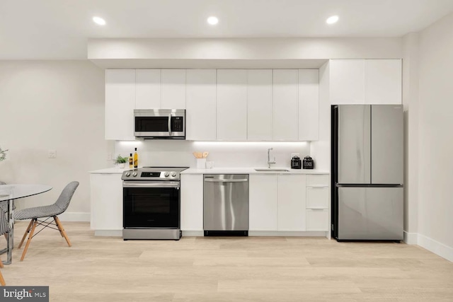 kitchen featuring white cabinetry, stainless steel appliances, and light hardwood / wood-style flooring