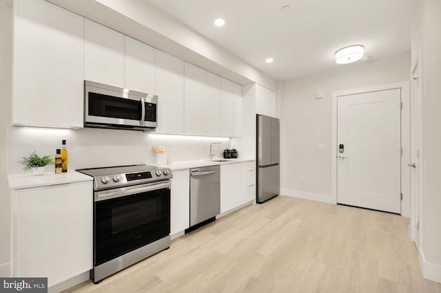 kitchen featuring white cabinetry, light hardwood / wood-style flooring, stainless steel appliances, and sink