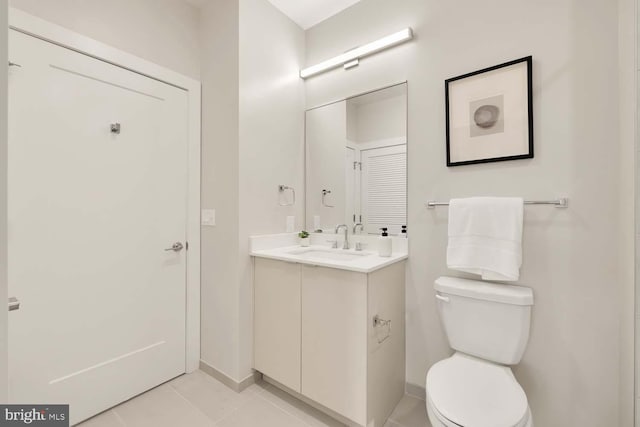 bathroom with tile patterned flooring, vanity, and toilet