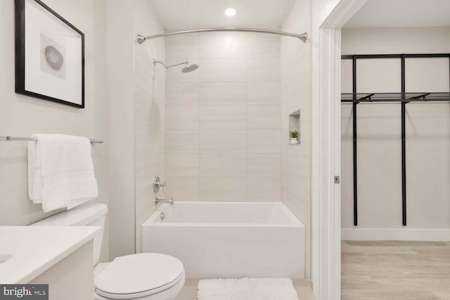 full bathroom with hardwood / wood-style flooring, vanity, toilet, and tiled shower / bath combo