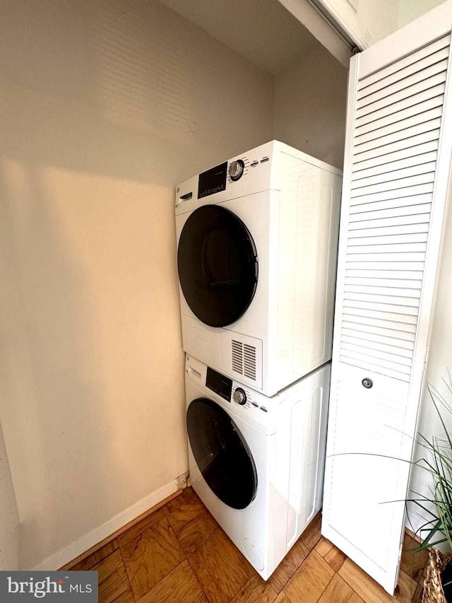 2201 L St NW Unit 906, Washington, DC 20037 - laundry room with stacked washing machine and dryer and baseboards