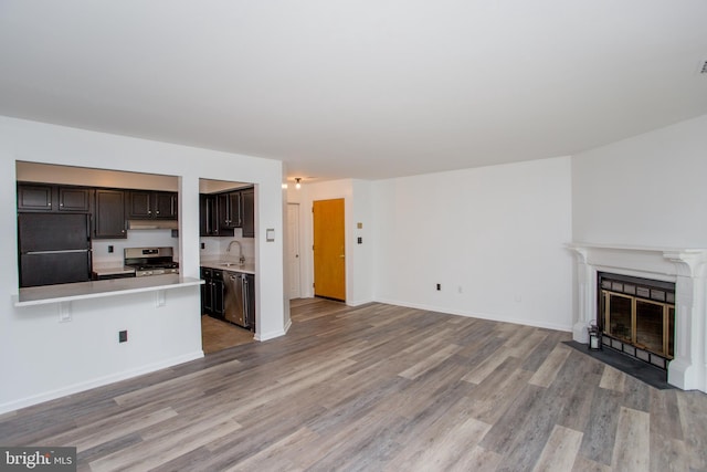 unfurnished living room featuring light hardwood / wood-style flooring and sink