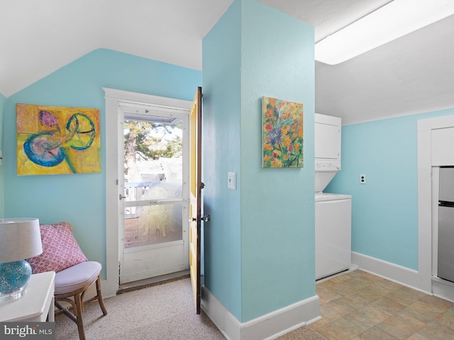 entryway with stacked washer and dryer and lofted ceiling