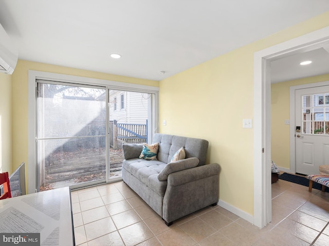 living room featuring light tile patterned floors and an AC wall unit